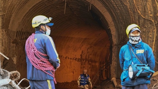 State Disaster Response Force (SDRF) personnel stand outside the entrance of Tapovan tunnel during rescue efforts in Uttarakhand's Chamoli district. (AFP) State Disaster Response Force (SDRF) personnel stand outside the entrance of Tapovan tunnel during rescue efforts in Uttarakhand's Chamoli district. (AFP)