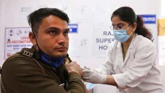 A health worker administers Covid-19 vaccine to a Delhi Police personnel at a hospital in New Delhi.(AP)