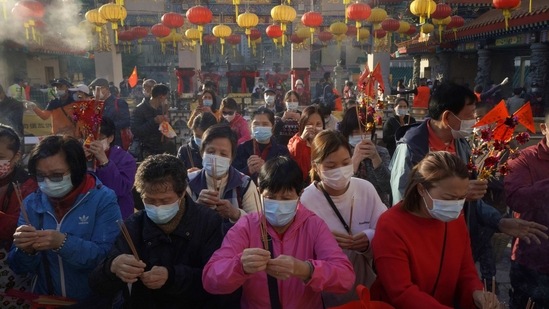 Worshippers wearing face masks burn joss sticks as they pray at the Wong Tai Sin Temple during Lunar New Year celebrations, in Hong Kong on February 12.(Kin Cheung / AP)