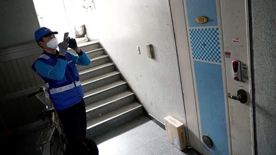 A delivery man for Coupang Jung Im-hong wearing a mask to prevent contracting the coronavirus, takes photographs of a package after delivering in Incheon, South Korea, March 3, 2020.(Reuters Photo) A delivery man for Coupang Jung Im-hong wearing a mask to prevent contracting the coronavirus, takes photographs of a package after delivering in Incheon, South Korea, March 3, 2020.(Reuters Photo)
