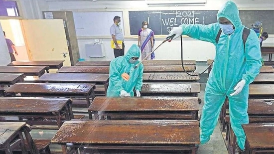 Employees in PPE kits sanitise a classroom at SIES College in Sion, Mumbai. SATISH BATE/HT PHOTO