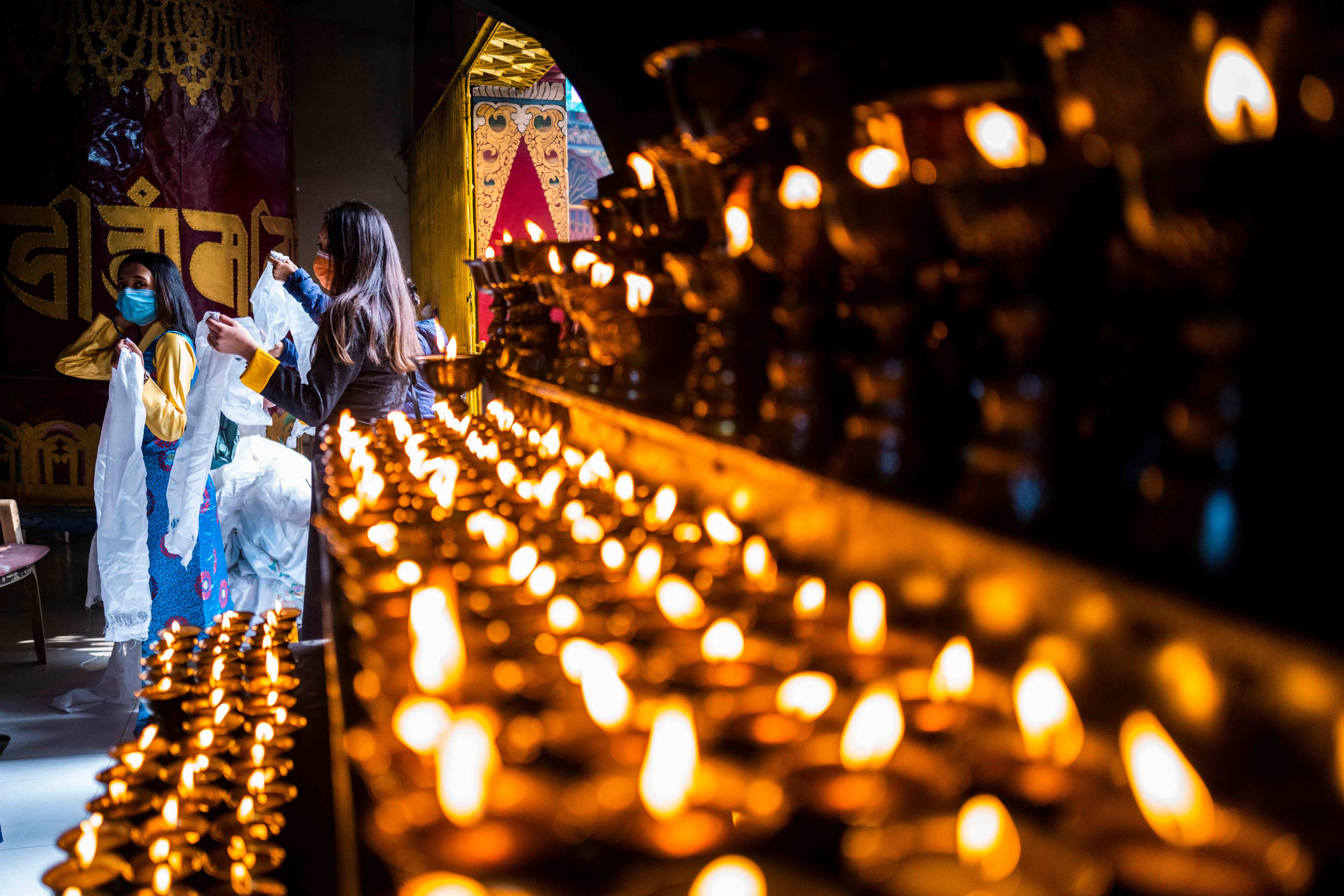 Tibetan refugees enter a temple to pray in New Delhi on February 12, 2021, during the first day of the Lunar New Year. (AFP)