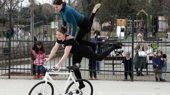 Acrobats Gioia Zanaboni, from Italy, top, and Anja Eberhart from Switzerland of the Zania company practice outside in a public park as their training center room is closed prior to presenting their acrobat show "Never Retiring" during the BIAC, International Circus Arts Biennale, in Marseille, south of France, Thursday, Feb. 4, 2021.(AP)