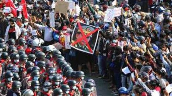 Protesters flashing three fingered salutes and holding an image with an X mark on a photo of Myanmar Commander-in-Chief Senior General Min Aung Hlaing face rows of riot police in Naypyitaw, Myanmar. (AP) Protesters flashing three fingered salutes and holding an image with an X mark on a photo of Myanmar Commander-in-Chief Senior General Min Aung Hlaing face rows of riot police in Naypyitaw, Myanmar. (AP)