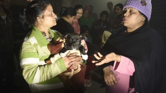 Residents - one holding a puppy- speak on a street in Amritsar late February 12, 2021, after leaving their homes as tremors shook the city in Punjab State north-western India following a powerful earthquake in Tajikistan of a magnitude of 5.9 according to the United States Geological Survey (USGS).(AFP)