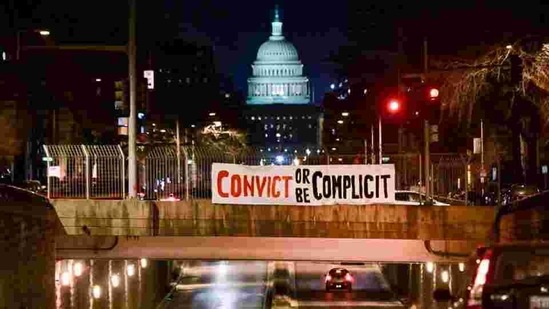 A banner is placed over a bridge with the US Capitol in the backdrop of the Senate impeachment trial against former president Donald Trump. (Reuters) A banner is placed over a bridge with the US Capitol in the backdrop of the Senate impeachment trial against former president Donald Trump. (Reuters)