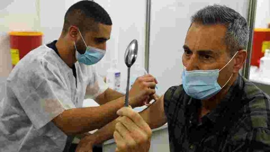Celebrity mystic Uri Geller holds a spoon as he performs his spoon-bending trick for medical staff while receiving a vaccination against the coronavirus disease (COVID-19), in Jaffa, near Tel Aviv, Israel. (REUTERS) Celebrity mystic Uri Geller holds a spoon as he performs his spoon-bending trick for medical staff while receiving a vaccination against the coronavirus disease (COVID-19), in Jaffa, near Tel Aviv, Israel. (REUTERS)
