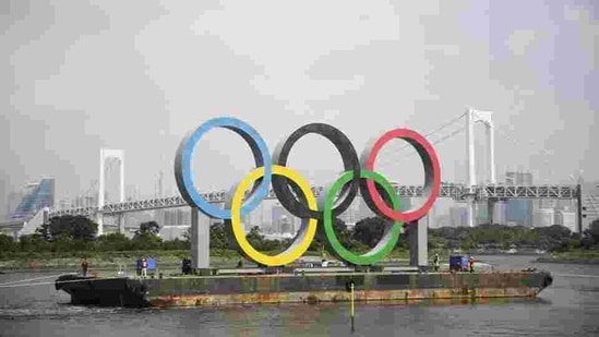 File photo, the Olympic rings for the Olympic and Paralympic Games Tokyo 2020 pass by on a barge by tugboats off the Odaiba Marine Park in Tokyo.(AP) File photo, the Olympic rings for the Olympic and Paralympic Games Tokyo 2020 pass by on a barge by tugboats off the Odaiba Marine Park in Tokyo.(AP)
