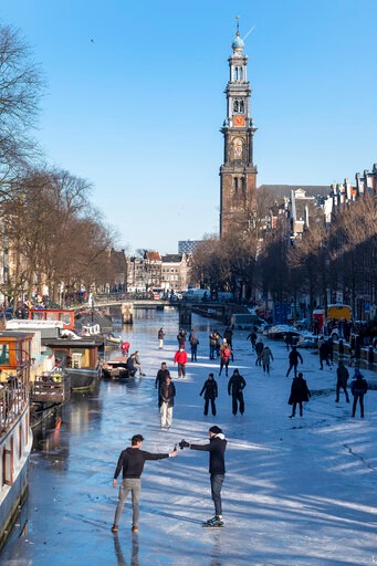 Two men propose a toast as dozens of skaters took to the frozen surface of Amsterdam's historic Prinsengracht canal.(AP) Two men propose a toast as dozens of skaters took to the frozen surface of Amsterdam's historic Prinsengracht canal.(AP)
