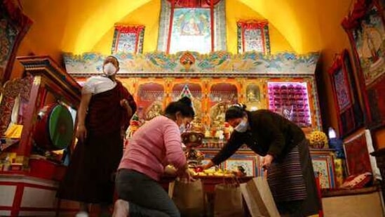 Lama Gelbu, left, Pasang Sherpa, center, and Yanddu Lama, right, prepare bags of fruit used as ceremonial offerings.(AP)