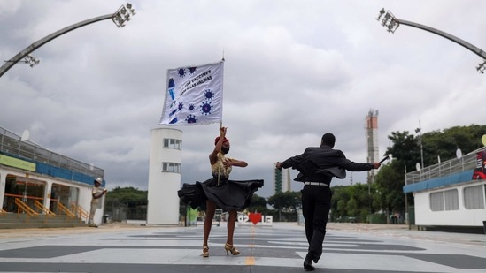 Paula Penteado and Reginaldo Pingo from Vai-Vai samba school dance on the phrase "All For Vaccines" written at Sao Paulo's Sambadrome, on February 13.(Amanda Perobelli / REUTERS)