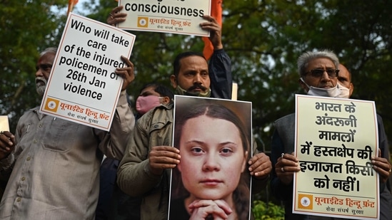Activists of United Hindu Front (UHF) hold placards and a picture of Swedish climate activist Greta Thunberg during a demonstration in New Delhi on February 4, 2021, after she made comments on social media about mass farmers' protests in India.(AFP)