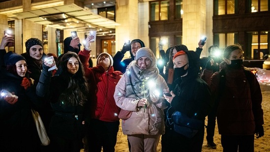 Young people turn on the flashlights of their mobile phones in support of jailed opposition politician Alexei Navalny near Red Square in Moscow.(AP)