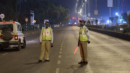 Mumbai: Police officers maintain vigil at Marine Drive during the night curfew in Mumbai, early Wednesday, Dec. 23, 2020. Maharashtra government imposed a night curfew between 11 pm and 6 am in municipal corporation areas as a precautionary measure amid growing concerns over the new coronavirus variant spreading in Britain.(PTI Photo/Kunal Patil)(PTI23-12-2020_000018A) (PTI) Mumbai: Police officers maintain vigil at Marine Drive during the night curfew in Mumbai, early Wednesday, Dec. 23, 2020. Maharashtra government imposed a night curfew between 11 pm and 6 am in municipal corporation areas as a precautionary measure amid growing concerns over the new coronavirus variant spreading in Britain.(PTI Photo/Kunal Patil)(PTI23-12-2020_000018A) (PTI)