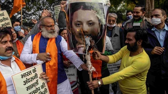 Activists of United Hindu Front (UHF) hold placards and a picture of Swedish climate activist Greta Thunberg during a demonstration in New Delhi on February 4, 2021, after she made comments on social media about mass farmers' protests in India.(AFP)