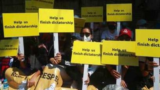 Anti-coup protesters hold placards that read: "Help us finish dictatorship" as they gather outside the U.N. Information Office in Yangon, Myanmar, Sunday, Feb. 14, 2021. Vast numbers of people all over Myanmar have flouted orders against demonstrations to march again in protest against the military takeover that ousted the elected government of Suu Kyi. (AP Photo) (AP) Anti-coup protesters hold placards that read: "Help us finish dictatorship" as they gather outside the U.N. Information Office in Yangon, Myanmar, Sunday, Feb. 14, 2021. Vast numbers of people all over Myanmar have flouted orders against demonstrations to march again in protest against the military takeover that ousted the elected government of Suu Kyi. (AP Photo) (AP)