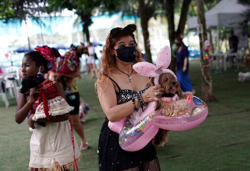 Francisca holds her pet dog Eva during the annual dog Carnival parade in Rio de Janeiro, Brazil. (AP) Francisca holds her pet dog Eva during the annual dog Carnival parade in Rio de Janeiro, Brazil. (AP)