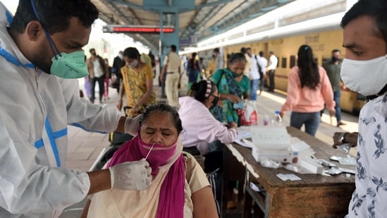 A health worker collects a swab sample from a passenger at the Dadar Terminal in Mumbai on February 12. Maharashtra on February 14 recorded over 4,000 Covid-19 cases after a gap of 39 days.(Satish Bate / HT Photo)