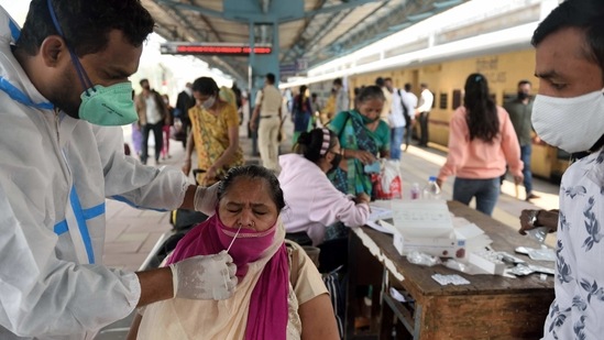 A health worker collects a swab sample from a passenger at the Dadar Terminal in Mumbai. Maharashtra.(Satish Bate / HT Photo)