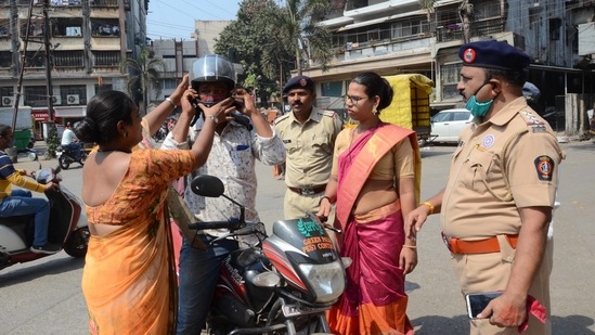 A volunteer from the transgender community assists a commuter during a traffic safety awareness drive in Kalyan on February 12. With the number of cases seeing an upward trajectory for the past four or five days, health experts have sounded an alarm to increase tracing and testing and urged citizens to strictly adhere to Covid-appropriate behaviour.(Rishikesh Choudhary / HT Photo)
