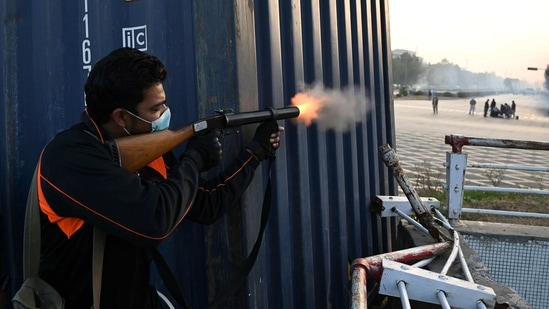 A policeman fires a teargas shell to disperse federal government workers as they try to march towards the Parliament House during a protest to demand higher wages, in Islamabad. (AFP) A policeman fires a teargas shell to disperse federal government workers as they try to march towards the Parliament House during a protest to demand higher wages, in Islamabad. (AFP)