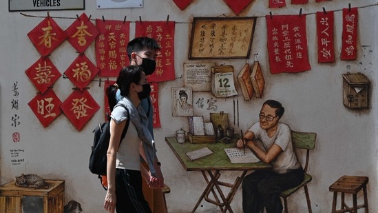 A couple walk past wall murals in a back alley in the Chinatown area of Singapore. (AP) A couple walk past wall murals in a back alley in the Chinatown area of Singapore. (AP)
