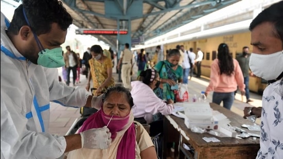 A BMC health worker takes a swab sample of a passenger at the Dadar Terminal in Mumbai. (Satish Bate/HT Photo)