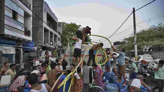 People fill their empty containers with water using lengths of hose pipe from a Delhi Jal Board tanker. (Burhaan Kinu/HT File Photo ) People fill their empty containers with water using lengths of hose pipe from a Delhi Jal Board tanker. (Burhaan Kinu/HT File Photo )