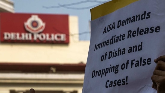 A demonstrator holds a placard during a protest against the arrest of 22-year-old climate activist Disha Ravi, outside the Delhi Police headquarters in New Delhi. (Reuters Photo)