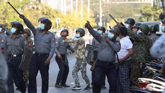 A policeman aims a slingshot towards an unknown target during a crackdown on anti-coup protesters outside the Myanmar Economic Bank in Mandalay on February 15. Soldiers and police had violently dispersed a gathering of more than 1,000 protesters outside the Myanmar Economic Bank on February 15. They attacked the protesters with slingshots and sticks, and police could be seen aiming long guns into the air amid sounds that resembled gunfire, AP reported.(AP / PTI)