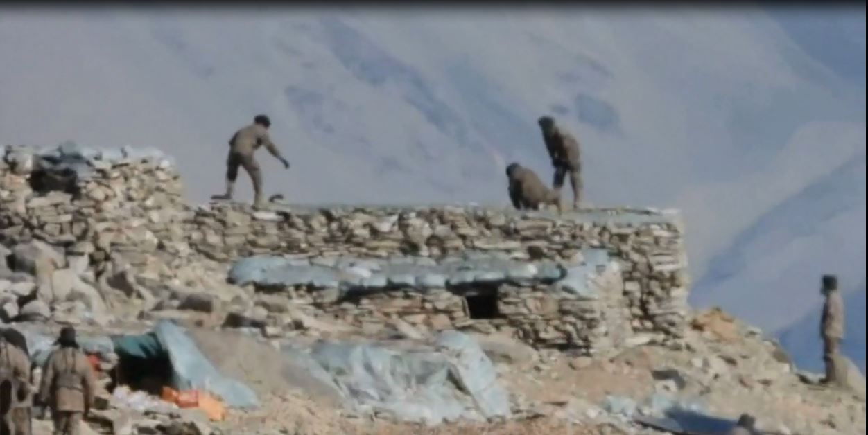 Sheets used for roofing being removed by Chinese soldiers (Indian Army)