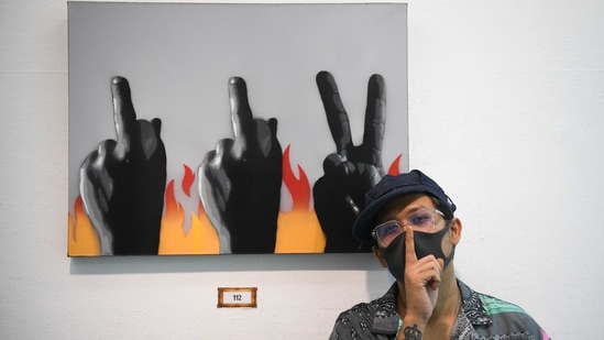 "Headache Stencil", a graffiti artist poses in front of his works during his "112 the Exhibition" at WTF Gallery and Cafe in Bangkok, Thailand, February 13, 2021.  (REUTERS)