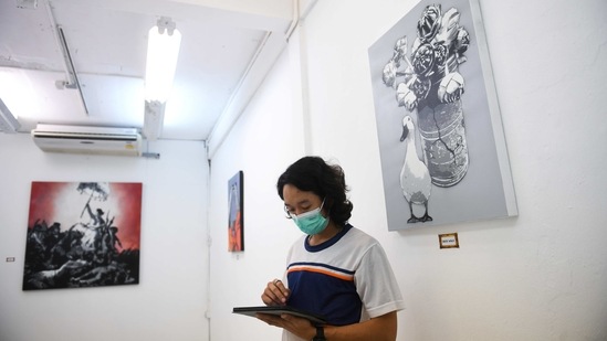 A man attends "112 the Exhibition" by graffiti artist "Headache Stencil" at WTF Gallery and Cafe in Bangkok, Thailand, February 13, 2021. (REUTERS)