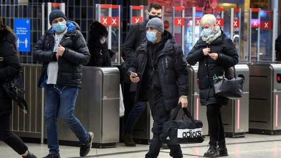 Passengers wearing protective masks enter an underground railway station in Stockholm, Sweden, January 7, 2021. (REUTERS)