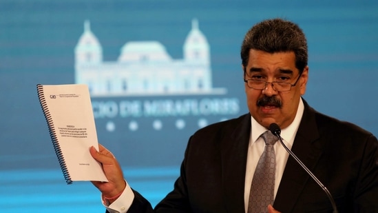 Venezuela's President Nicolas Maduro shows a document from the government administration office during a news conference in Caracas, Venezuela.(Reuters)