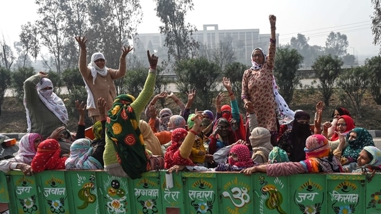 Villagers shout slogans as they sit inside the lorry of a tractor to go to the Tikri Delhi-Haryana state border to support protesting farmers, at the Makrauli village in Haryana.