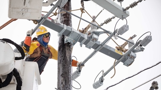 A worker repairs a power line in Austin, Texas, US.(Bloomberg)