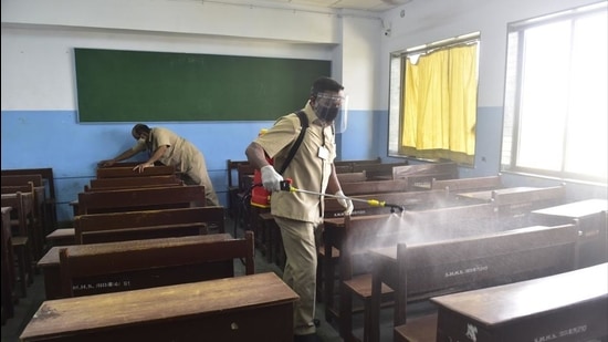 School employees sanitise a class room. (HT FILE PHOTO)