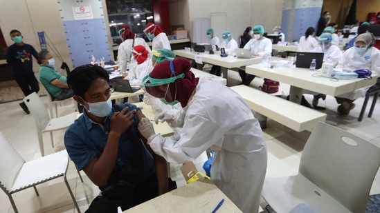 A man receives a shot of COVID-19 vaccine during a mass vaccination for traders at Tanah Abang Market in Jakarta, Indonesia, Thursday, Feb. 18, 2021. Public workers, people over 60 and traders and security personnel are next in line for COVID-19 shots in Indonesia, after more 1.1 million mostly health workers received the vaccine in the first phase of inoculation.(AP Photo/Achmad Ibrahim)(AP)