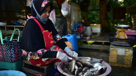 A vendor prepares freshwater fish at a roadside market in southern Thailand's Narathiwat province.(AFP)