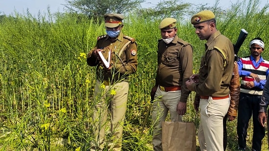 Police personnel at the site where bodies of two minor Dalit girls were found in a field on Wednesday evening, in Unnao district.(PTI Photo)