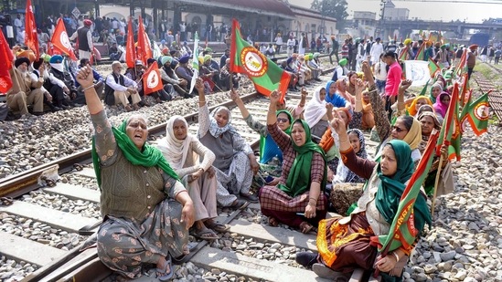 Members of various farmer organisations sit blocking a railway track in Patiala on February 18. The three farm laws enacted last year, have been projected by the government as major reforms in the agriculture sector that will remove middlemen and allow farmers to sell anywhere in the country.(PTI)