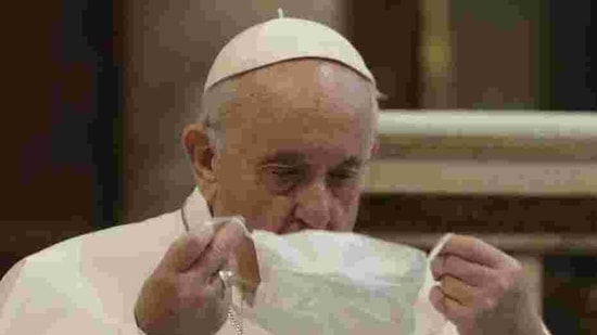 Pope Francis puts on his face mask as he attends an inter-religious ceremony for peace in the Basilica of Santa Maria in Aracoeli, in Rome. (AP)