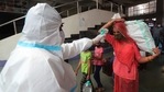 A health worker checks the temperature of a passenger at Bandra train station in Mumbai.(AP) A health worker checks the temperature of a passenger at Bandra train station in Mumbai.(AP)