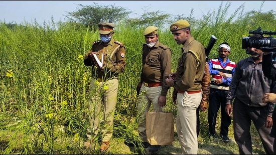 Police personnel investigate at the site where bodies of two minor Dalit girls were found in a field and another in critical condition on Wednesday evening, near Baburaha village in Unnao district, Thursday. (PTI)