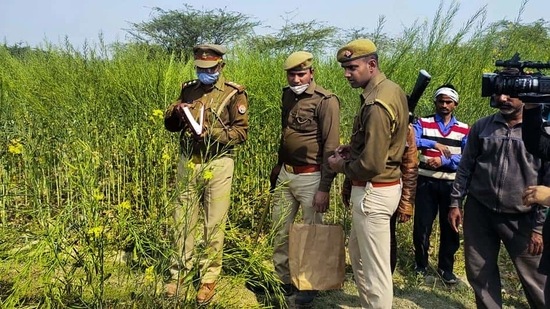 Police personnel investigate at the site where bodies of two minor Dalit girls were found in a field and another in critical condition on Wednesday evening, (PTI) Police personnel investigate at the site where bodies of two minor Dalit girls were found in a field and another in critical condition on Wednesday evening, (PTI)