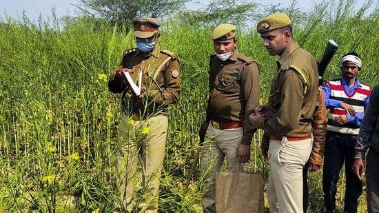 Police personnel investigate the site where bodies of two minor Dalit girls were found and another in critical condition on Wednesday evening near Baburaha village in Uttar Pradesh's Unnao district. (HT_PRINT)