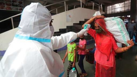 A health worker checks the temperature of a passenger at Bandra.(AP)