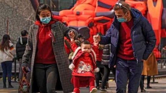 A couple wearing face masks to help curb the spread of the coronavirus lifts their child wearing a new year costume as they visit to the capital city's popular shopping mall during the first day of the Lunar New Year in Beijing, Friday, Feb. 12, 2021. Festivities for the holiday, normally East Asia's busiest tourism season, are muted after China, Vietnam, Taiwan and other governments tightened travel curbs and urged the public to avoid big gatherings following renewed virus outbreaks. (AP Photo/Andy Wong)(AP) A couple wearing face masks to help curb the spread of the coronavirus lifts their child wearing a new year costume as they visit to the capital city's popular shopping mall during the first day of the Lunar New Year in Beijing, Friday, Feb. 12, 2021. Festivities for the holiday, normally East Asia's busiest tourism season, are muted after China, Vietnam, Taiwan and other governments tightened travel curbs and urged the public to avoid big gatherings following renewed virus outbreaks. (AP Photo/Andy Wong)(AP)