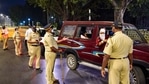 Police officers stop commuters at Girgaum Chowpatty during night curfew in Mumbai, early Wednesday, Dec. 23, 2020. (PTI) Police officers stop commuters at Girgaum Chowpatty during night curfew in Mumbai, early Wednesday, Dec. 23, 2020. (PTI)